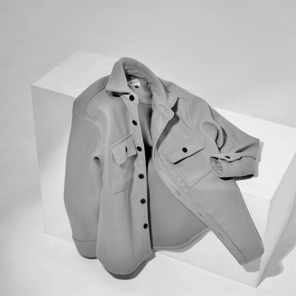 Gray shirt displayed on a geometric white block with a minimalist style.